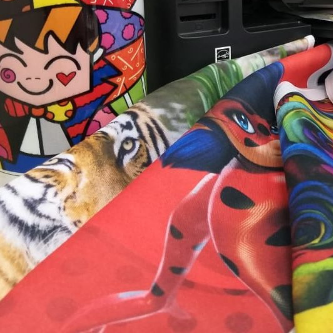 Tecido estampado por sublimação digital de alta definição. Detalhe de estampa colorida vibrante (personagens e animal print) sem toque e sem relevo.